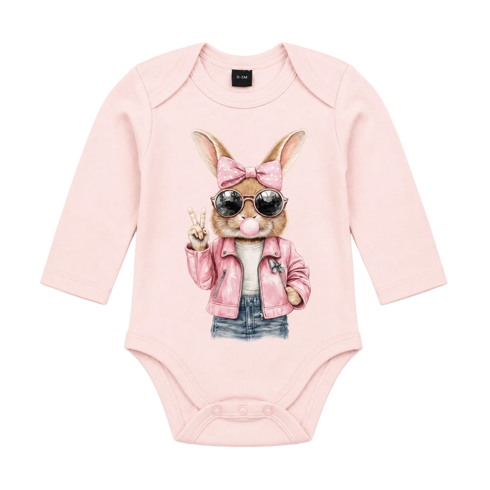 A light pink long-sleeve baby bodysuit featuring a graphic print of a cartoon rabbit wearing a pink bow, sunglasses, a pink leather jacket, and denim jeans, making a peace sign.