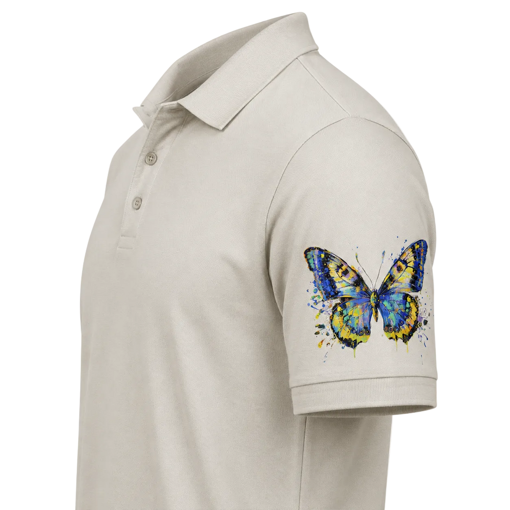 A light beige short-sleeve polo shirt shown from the side, featuring a colorful watercolor-style butterfly graphic printed on the upper left sleeve.